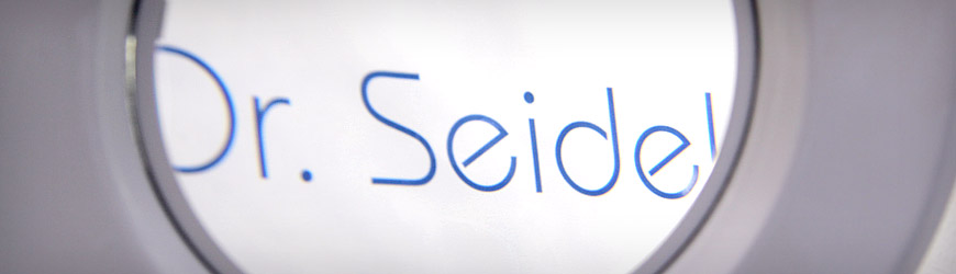 Logo Praxis Dr. Seidel durch eine Linse